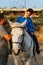 Boy with multiple disabilities having an equine therapy session with a physiotherapist.