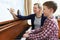 Boy With Music Teacher Having Lesson At Piano