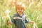 Boy in the nature. A child in the tall grass. Spring or summer mood. Sunny day. Happy childhood. Walk. Life.