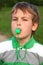 Boy on nature, plays, whistles in green whistle