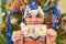 A boy in a New Year`s hat holds a 100 dollar bill in his hand against the background of a festive New Year tree