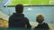 Boy with older brother watching training of football team at stadium, emotions