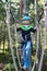 Boy overcoming hanging ropes obstacle