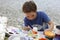 Boy painting clay figure