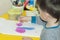 A boy paints a drawing on a piece of paper