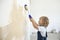 Boy paints the wall roller