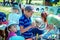 Boy, participating at art and craft outdoors workshop, painting colorful house