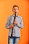 The boy performs solo at a concert, plays the clarinet on an orange background