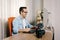 Boy photographer working from home on his computer. On the table are an electronic graphics tablet and a photo camera with a