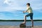 The boy on the pier, on a background of blue sky and lake, catches a fish on a bait