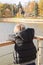 Boy on the pier looking at the water and gulls and ducks. view from the back. on the river calm and silence.