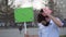 A boy in a pink gas mask at a rally with a banner in his hands closeup 4k.