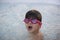 Boy with pink swimming goggles having fun in a hydromassage bath