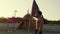 Boy with pirate flag in hand near his hut on the desert island