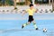 Boy play football on the blue concrete floor.