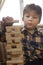 Boy play Jenga game together. child playing at home intrerior