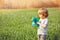 Boy play soap bubbles standing together over spring green field