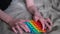 Boy playing with anti-stress rainbow pop it fidget toy