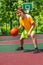 Boy playing with ball alone during basketball game