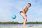 A boy playing with a ball in the sand on the beach.  Sports  games in the open air