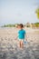 Boy playing on beach. Child play at sea on summer family vacation. Sand and water toys, sun protection for young child. Little boy