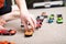 Boy playing with car collection on carpet.Child hand play. Transportation, airplane, plane and helicopter toys for children