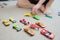 Boy playing with car collection on carpet.Child hand play. Transportation, airplane, plane and helicopter toys for children