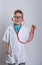 Boy playing doctor with a stethoscope. Kid in glasses isolated over white. Thumb up. White clothes