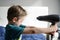 Boy playing with electrical hair dryer