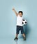 Boy playing football, happy child, young male teen goalkeeper enjoying sport game, holding ball, portrait of a preteen smiling