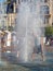 Boy is playing in the fountain. Wet child in the fountain. Splashes of water on a person. Wet clothes on the guy.