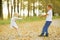 Boy playing with a girl in autumn country road