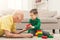 Boy playing with grandfather in building kit