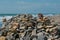 Boy playing, hiding behind a fortress of stones on the sea shore beach.