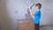 Boy playing with mounting foam while parents don\'t see him. Renovation at home.