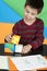 Boy playing with multicolored cubes