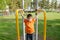 Boy playing outdoors on horizontal bar gym. Kid on playground,children activity. Child having fun. Active healthy childhood