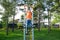 Boy playing outdoors on horizontal bar gym. Kid on playground, children activity. Child having fun. Active healthy concep