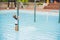 Boy playing in the paddling pool in the summertime