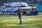 A boy is playing paintball on the field. two teams of paintball players in camouflage form with masks, helmets, guns on the field