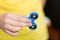 A boy is playing a popular toy fidget spinner in his hands.