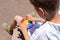 Boy playing with rainbow anti stress pop it toy, outdoors