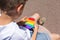 Boy playing with rainbow anti stress pop it toy, outdoors