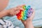 Boy playing with rainbow pop it fidget toy. Push bubble fidget sensory toy - washable and reusable silicon stress relief