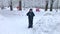 A boy playing snowballs in snowy winter park - childhood, leisure and season concept