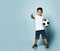 Boy playing soccer, happy child, young male teenager goalkeeper enjoying sports game, holding ball