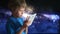 Boy playing with tablet pc. Boy and tablet device in hands sitting on the background of cosmic sky