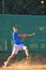 Boy playing tennis hitting the ball with backhand