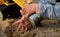 Boy playing with a yellow excavator, his hands and toothed wheels are visible. Hands playing in the sand in the sandbox preschool