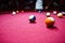 Boy plays billiard or pool in club. Young Kid learns to play snooker. Boy with billiard cue strikes the ball on table.